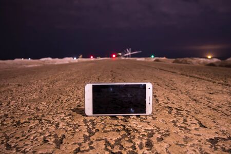 Smartphone on the ground in the middle of the evening roadの写真素材