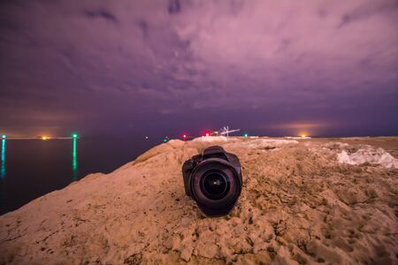 A professional camera on the sea shore at night