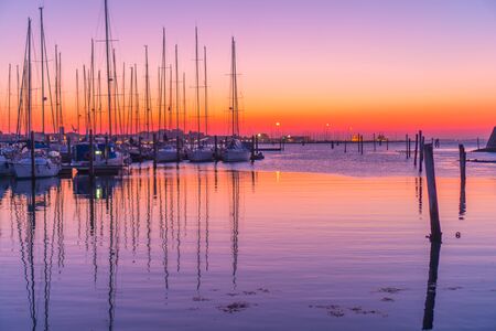 Red sunset on the harbor of sailboatsの写真素材