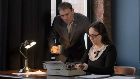 Young Woman Typewriter Accountant Writing Text of her Boss by Using Retro Typing Machine