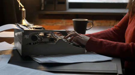 Closeup of Female Journalist or Writer Using Retro Typing Machine to Create Text