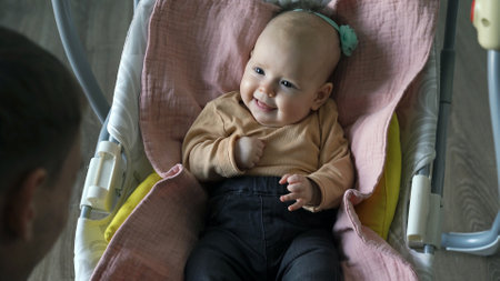Father playing with his baby girl sitting in electric swings. Family and lifestyle concept