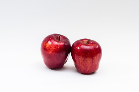 view of two red apples on white background