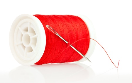 Reel with thread and needle on a white background