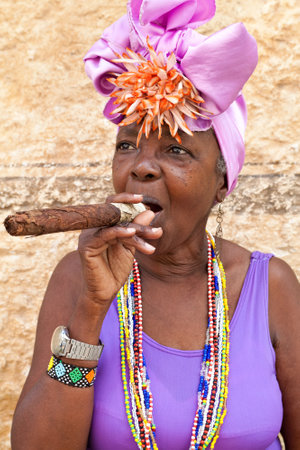 HAVANA-MARCH 28:Woman with typical clothes and a huge cuban cigar March 28,2011 in Havana.People dressed in a way that represents the cuban nationality can still be found in the streets of Old Havanaのeditorial素材
