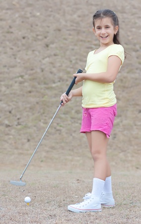 Adorable latin girl playing golf and smilingの写真素材