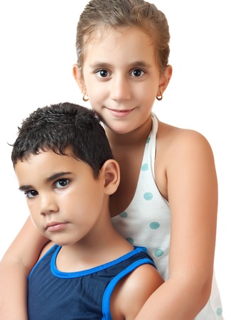 Latin girl hugging her younger brother isolated on a white backgroundの写真素材