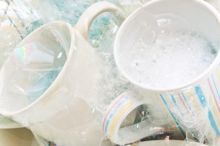 Washing dirty glasses and dishes with detergent and waterの写真素材