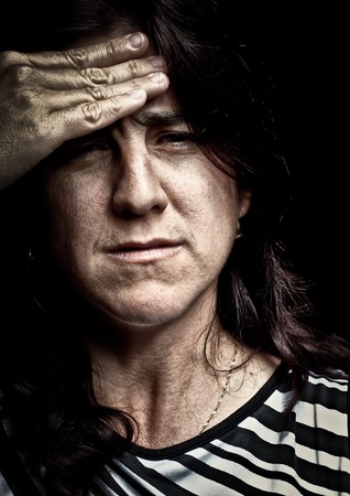 Grunge image of a very stressed woman suffering from depression or headacheの写真素材