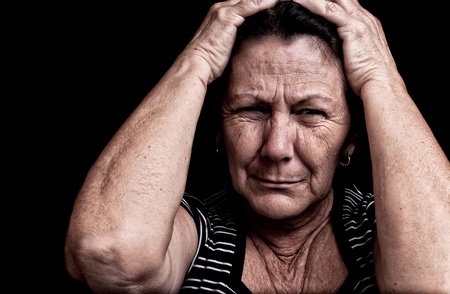 Grunge portrait of an old woman suffering from a headache with a desperate expressionの写真素材