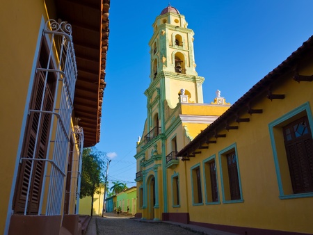 Old church sidelined by colorful houses in the colonial town of Trinidad in Cuba, a famous touristic landmark on the caribbean islandの写真素材