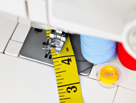 Sewing machine , reels with thread and a yellow measuring tape
