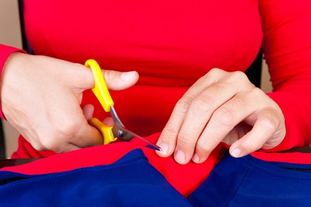 Close up of hands cutting a piece of fabric