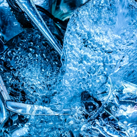 Detail of blue toned cutlery and glasses being washed with water and detergentの写真素材