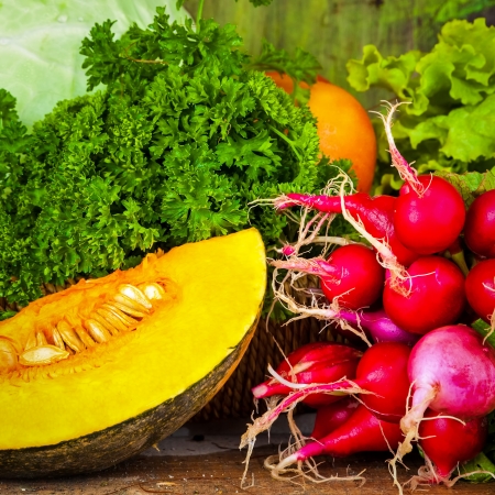 Close up of various fresh and colorful vegetables over wood useful to illustrate healthy or vegetarian foodの写真素材