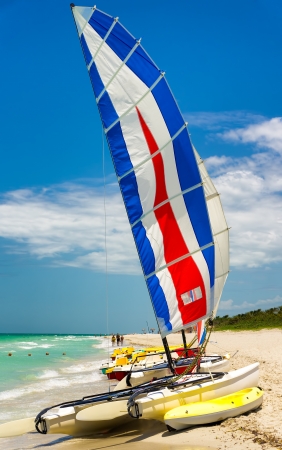 Colorful catamaran with its sails painted in bright colors on the beach of Varadero in Cubaの写真素材