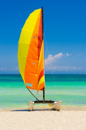 Catamaran with its colorful sails wide open landed on the famous Varadero beach in Cubaの写真素材