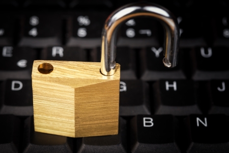 Open padlock on a black computer keyboard useful to illustrate data security