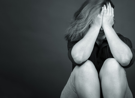 Black and white emotional image of a sad and lonely woman crying  with space for text の写真素材
