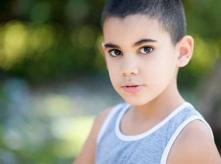 Portrait of a latin child with a diffused green vegetation backgroundの写真素材