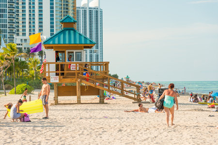 People enjoying the beach near an iconic lifeguard tower in South Beach on a beautiful summer dayのeditorial素材