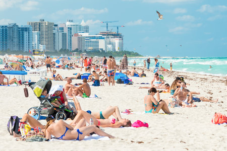 MIAMI,USA - MAY 20,2014  People enjoying the beach at South Beach with the city skyline on the backgroundのeditorial素材