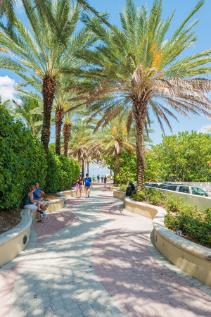 People enjoying the weather and walking along a seaside path in South Beachのeditorial素材