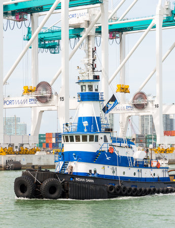 Tugboat sailing in the Port of Miami with containers and cranes on the backgroundのeditorial素材