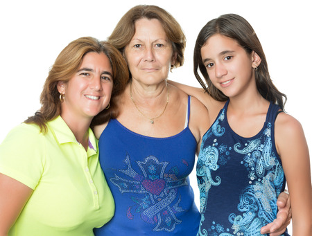 Three generations of hispanic hugging women isolated on white