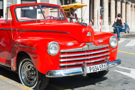 HAVANA,CUBA - NOVEMBER 6,2014 : Beautiful and shiny vintage red Ford car parked next to a hotelのeditorial素材