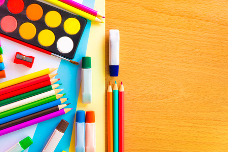 Colorful art supplies on a school desk with space for text