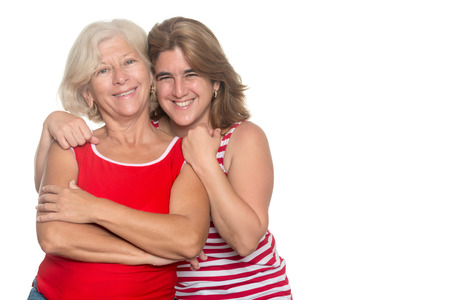 Adult hispanic woman hugging her older mother isolated on whiteの写真素材