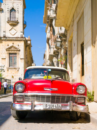 Vintage red car on a narrow street on the colonial neighborhood of Havana