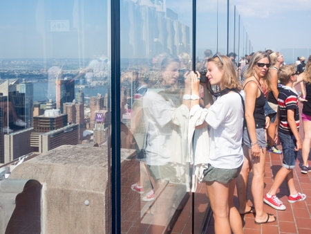 Tourist taking photographs at the Top of the Rock observation Deck atop the GE Building on the Rockefeller Centerのeditorial素材