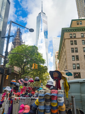 Street scene in New York City with souvenirs for sale and a view of the One World Trade Center tower in  downtown Manhattanのeditorial素材