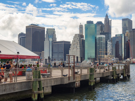 People at a pier in Brooklyn with the Lower Manhattan skyline on the backgroundのeditorial素材