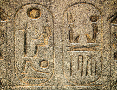 Ancient egyptian hieroglyph carved in stone  with cartouches enclosing royal names