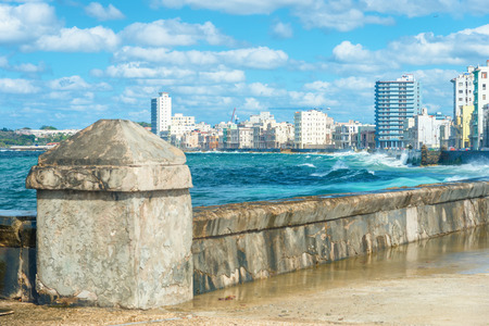 The Havana skyline with big sea waves crashing on the Malecon seawallの写真素材