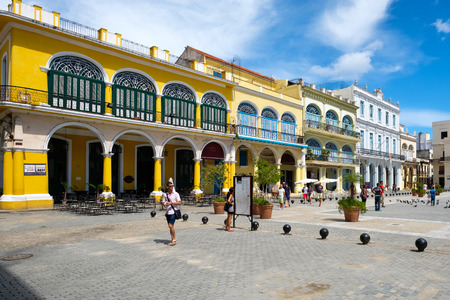 Tourists and locals at a colorful square on Old Havanaの写真素材