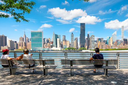 NewYorkers relaxing at a park in Queens with a view of the midtown Manhattan skylineのeditorial素材