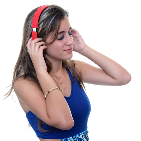 Pretty teenage girl  enjoying music on wireless headphones with her eyes closed - Isolated on whiteの写真素材