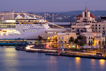 Old Havana at sunset with a view of historic buildings and a modern cruise ship docked at the bayの写真素材