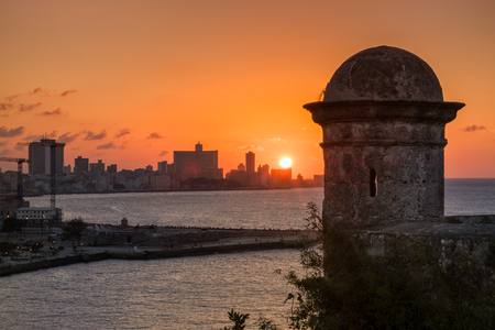 The city of Havana at sunset with an old tower from a historic fortress on the foregroundの写真素材