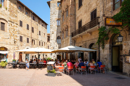 SAN GIMIGNANO,ITALY - JULY 23,2017 : Tourists at a restaurant on the medieval town of San Gimignano in Tuscanyのeditorial素材