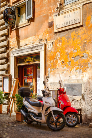 Typical street scene in Rome with scooters on an old narrow cobblestoned streetのeditorial素材