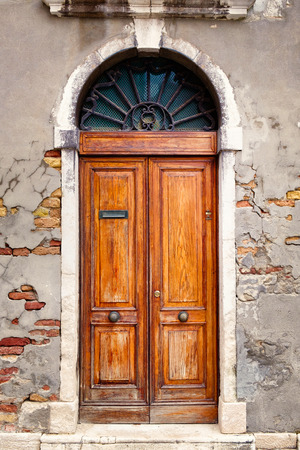 Beautiful vintage wooden door on an old wall with exposed bricksの写真素材