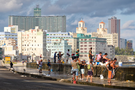 Fishermen at the famous Malecon seawall in Havana with a view of the city skylineのeditorial素材