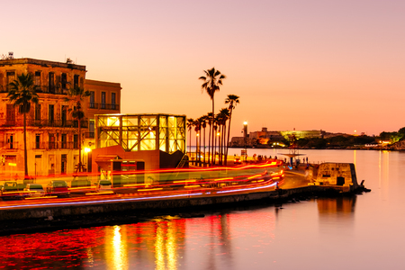 Colorful sunset in Havana with a view of the ocean, the old city and the colonial fortresses across the bayの写真素材