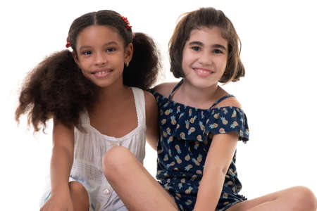 Two friendly small girls, friends or sisters  - Hispanic and african-american - Isolated on whiteの写真素材