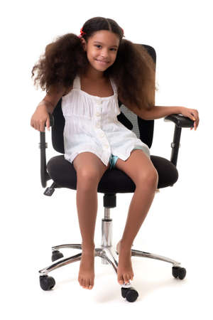 Cute multiracial small girl sitting on an office chair - Isolated on a white backgroundの写真素材